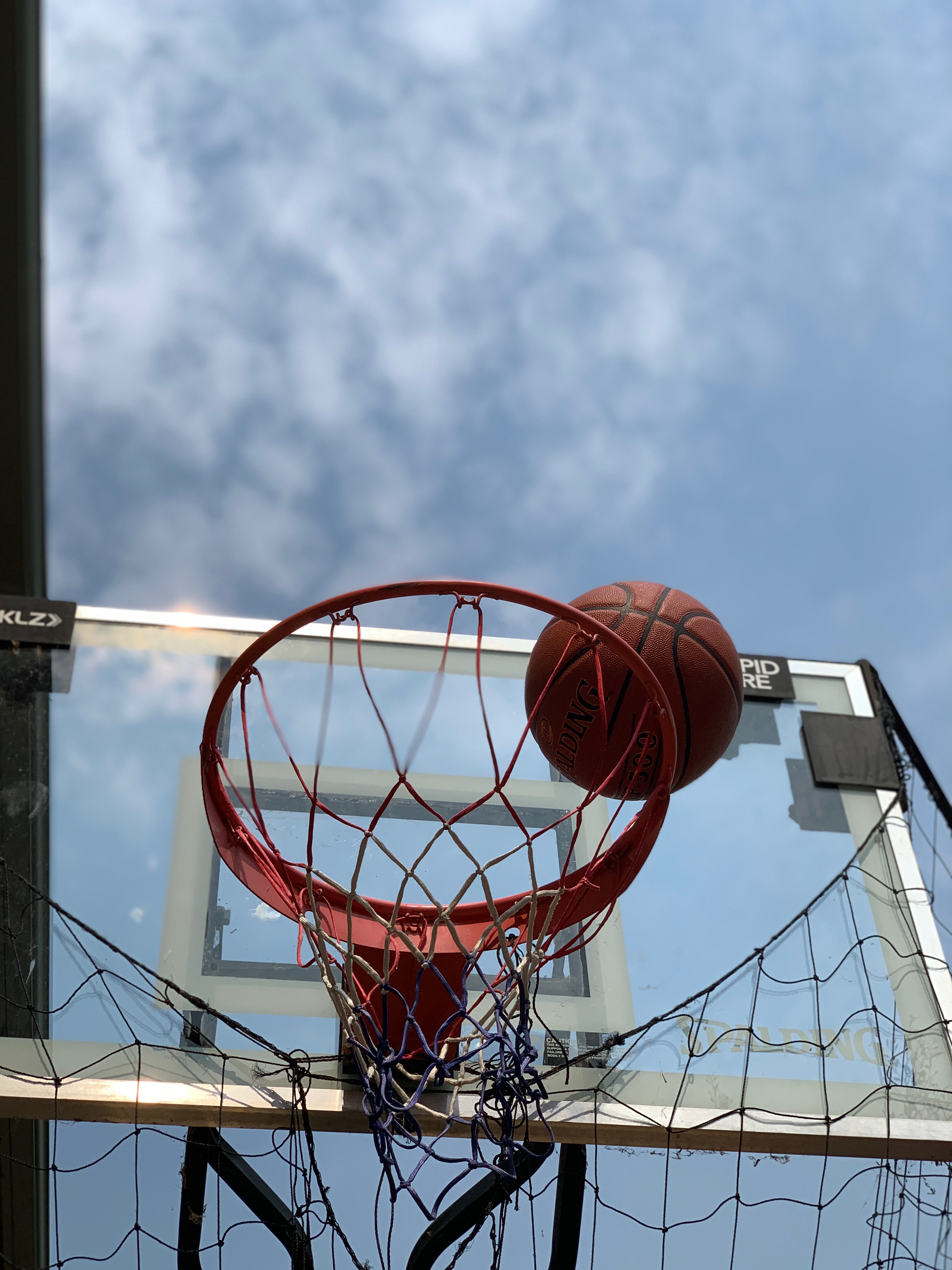 B&W picture of basketball leaving net of basketball hoop